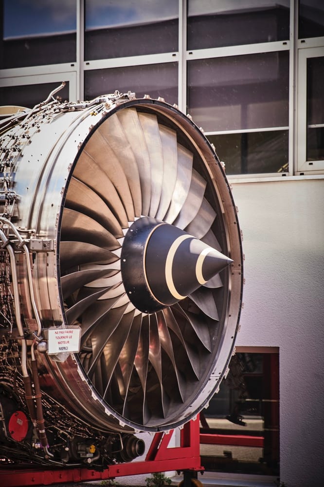 A salvaged turbofan engine on a wheeled stand after removal from the airframe.