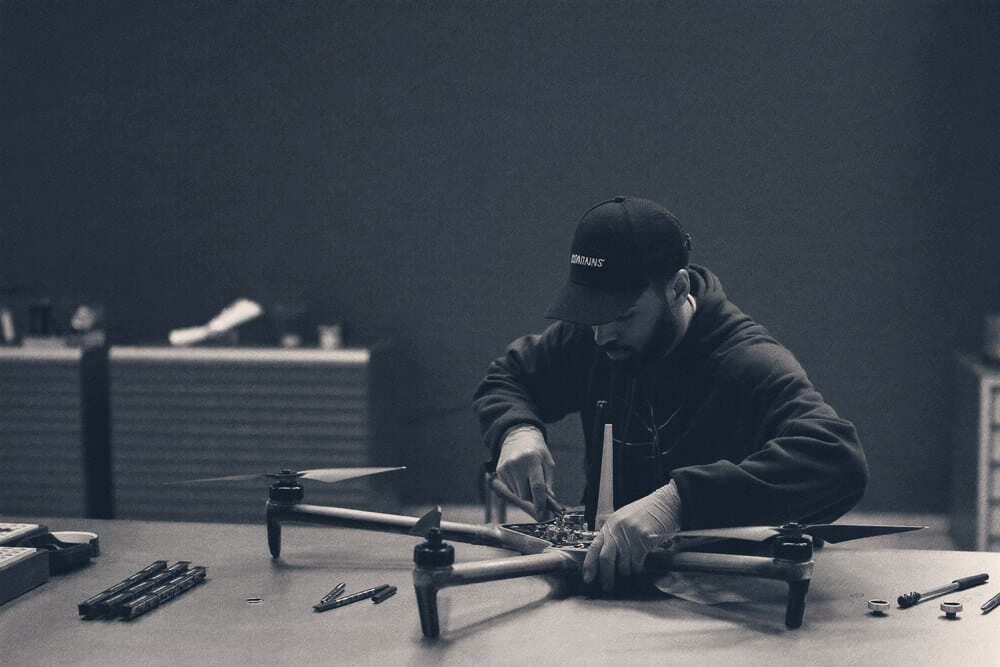Un technicien démonte un drone professionnel sur un établi