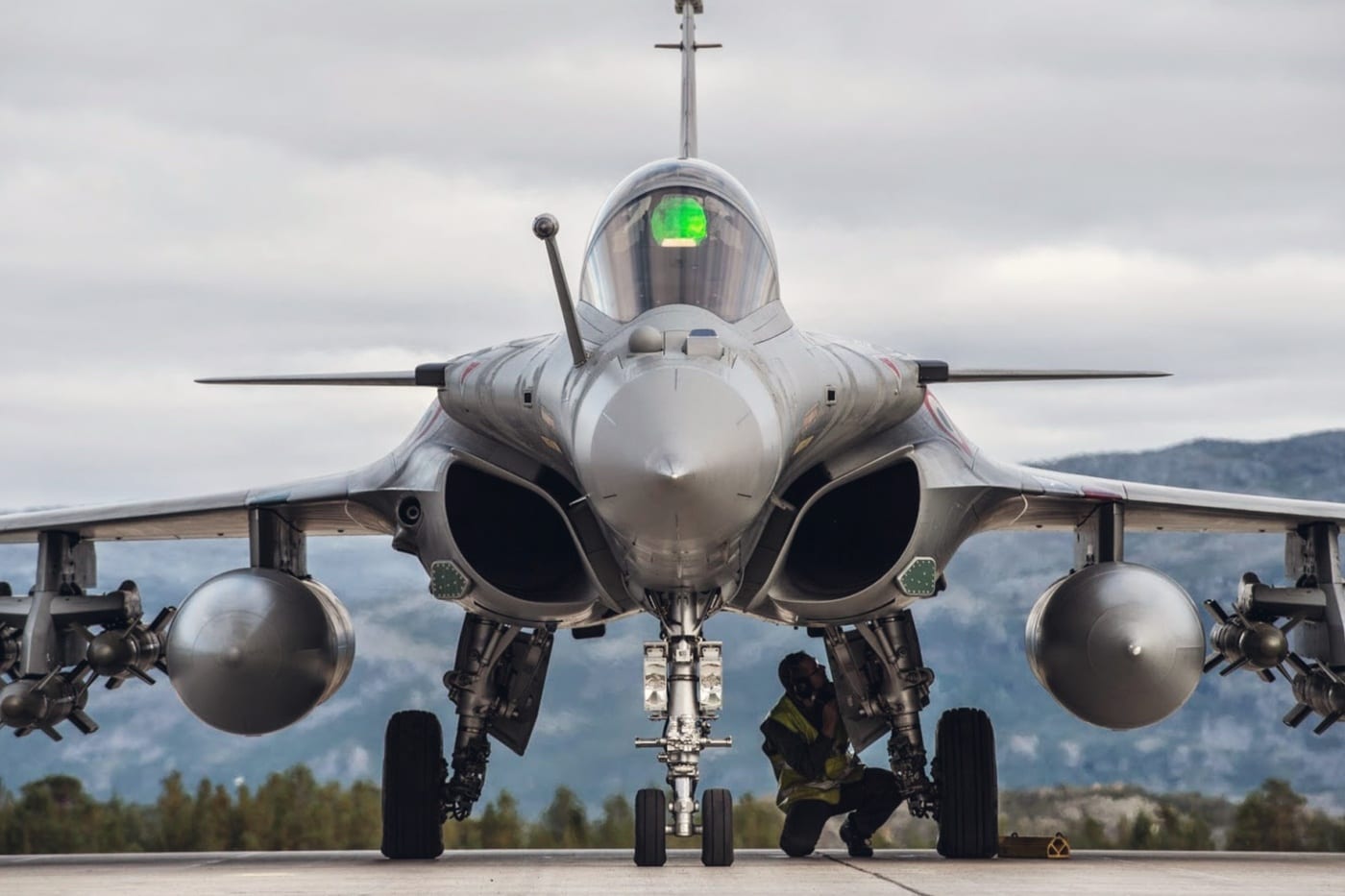 Un Rafale de face sur une aire de trafic, un membre de l’équipe au sol accroupi sous le nez