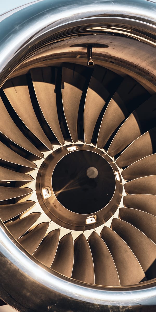 La soufflante d’un moteur de jet d’affaires vue de face, aubes et lèvre d’entrée d’air polie remplissant le cadre